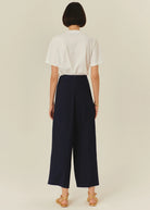 Back view High-rise wide-leg trousers in navy styled with a crisp white blouse