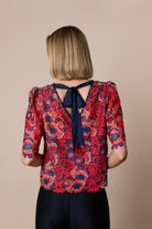 Back view of Fee G Lori floral lace top with navy statement bow