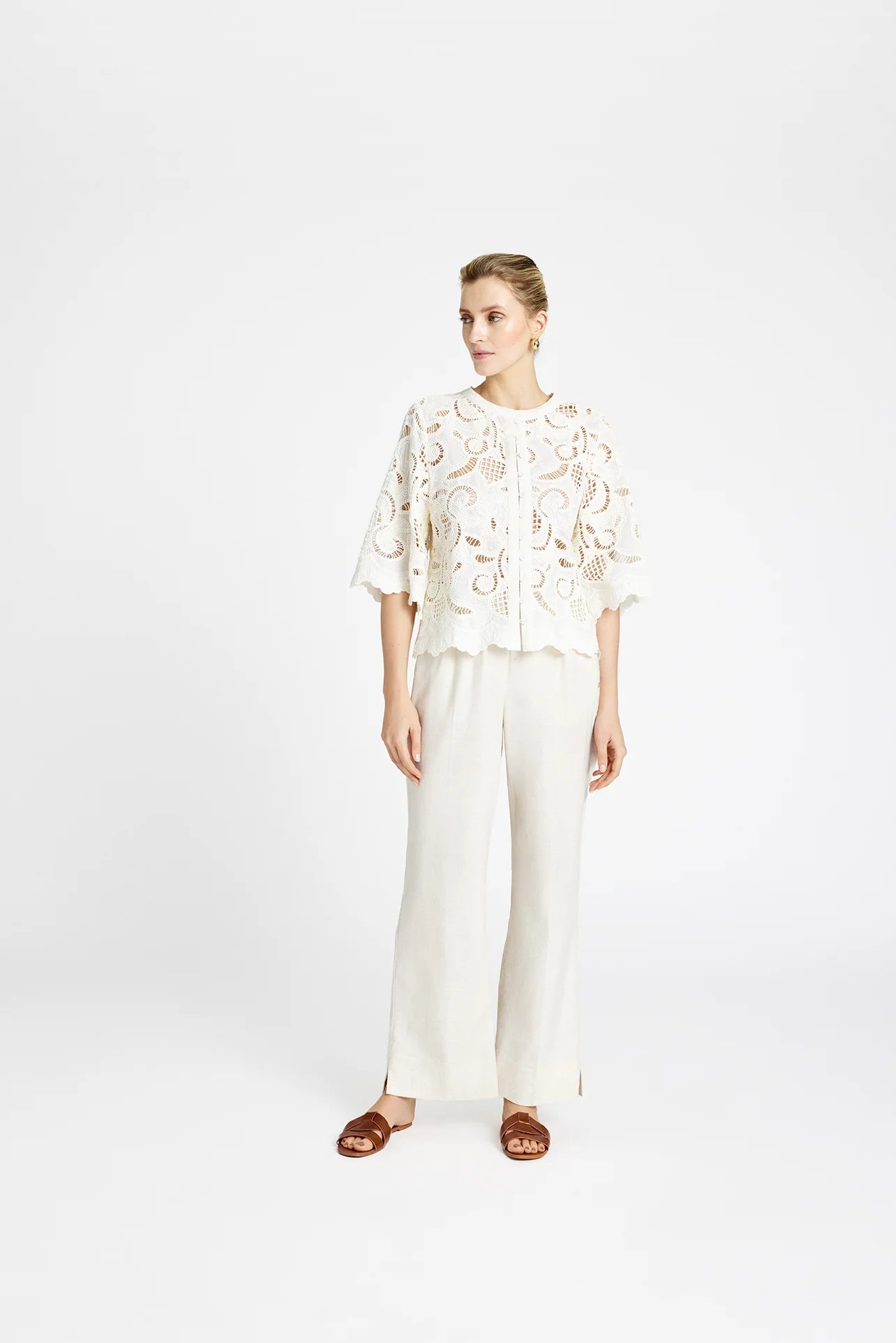 Model wearing Gustav Grazia white embroidered lace shirt with wide-leg trousers