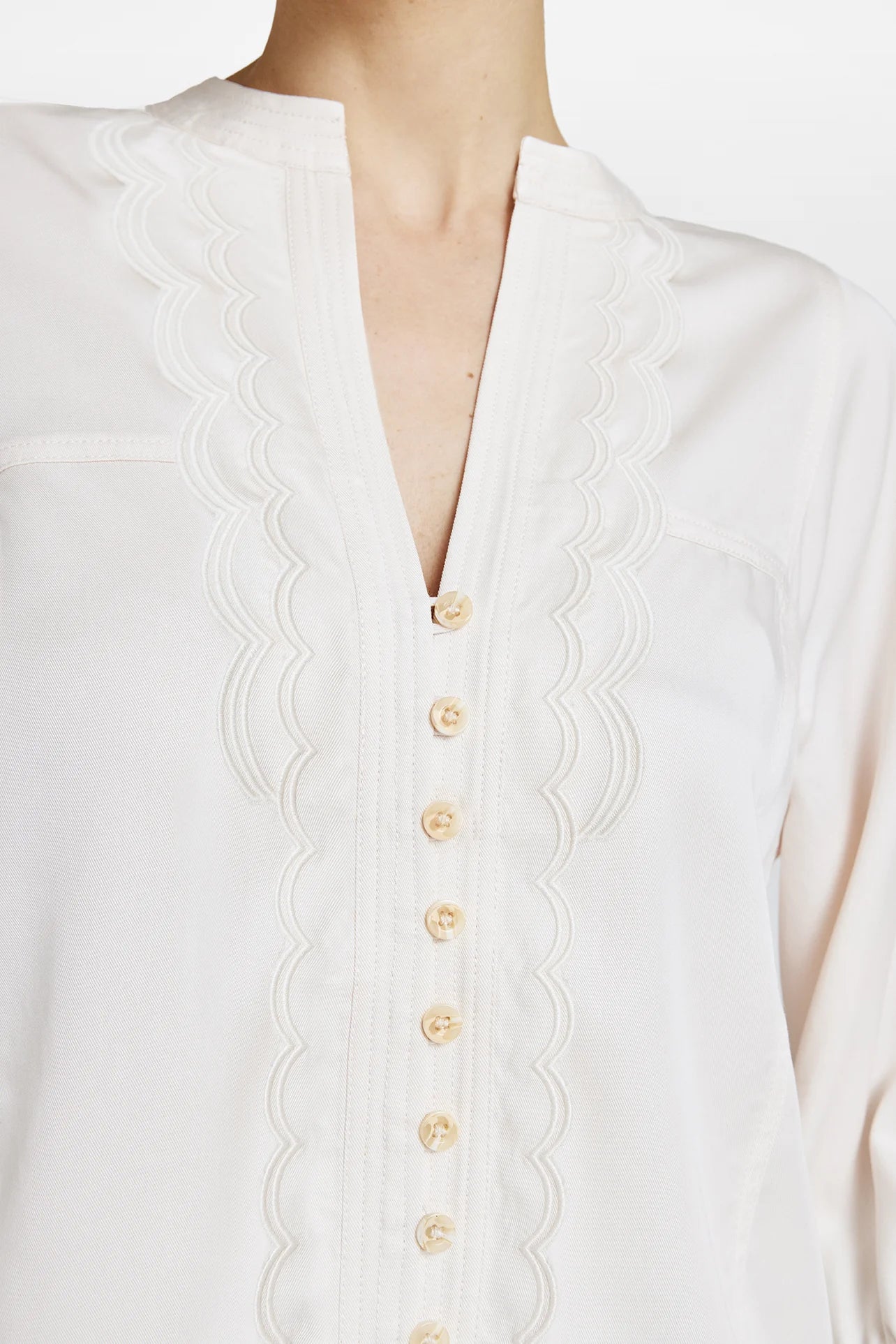 Close-up of scalloped frill trim and tonal buttons on the Gustav Kaisa cream lyocell blouse.”
