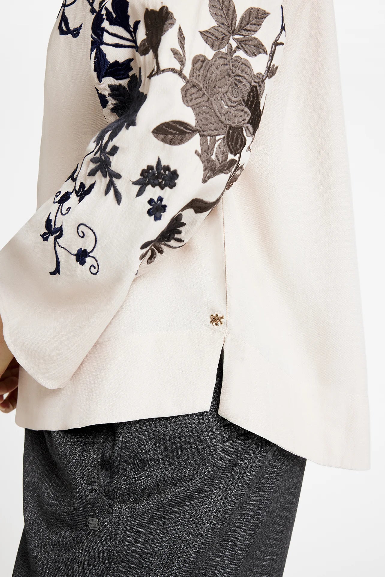 Front angled view of Gustav Naja embroidered blouse in ivory with navy floral design.