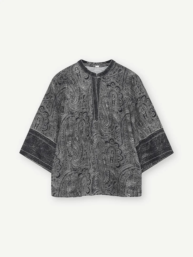 The Gustav Neomi blouse brings a black and sand paisley print to a relaxed silhouette with wide three-quarter sleeves. A contrast border frames the neckline and returns at the cuffs, breaking up the all-over pattern. Wear it with the matching Gustav Babbett paisley trousers for the full co-ord. For daytime, pair it with black denim to keep the focus on the print.