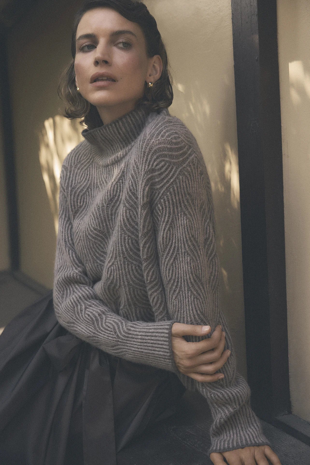 Gustav Marita pure wool cable knit jumper worn by model, showing textured knit and relaxed silhouette.