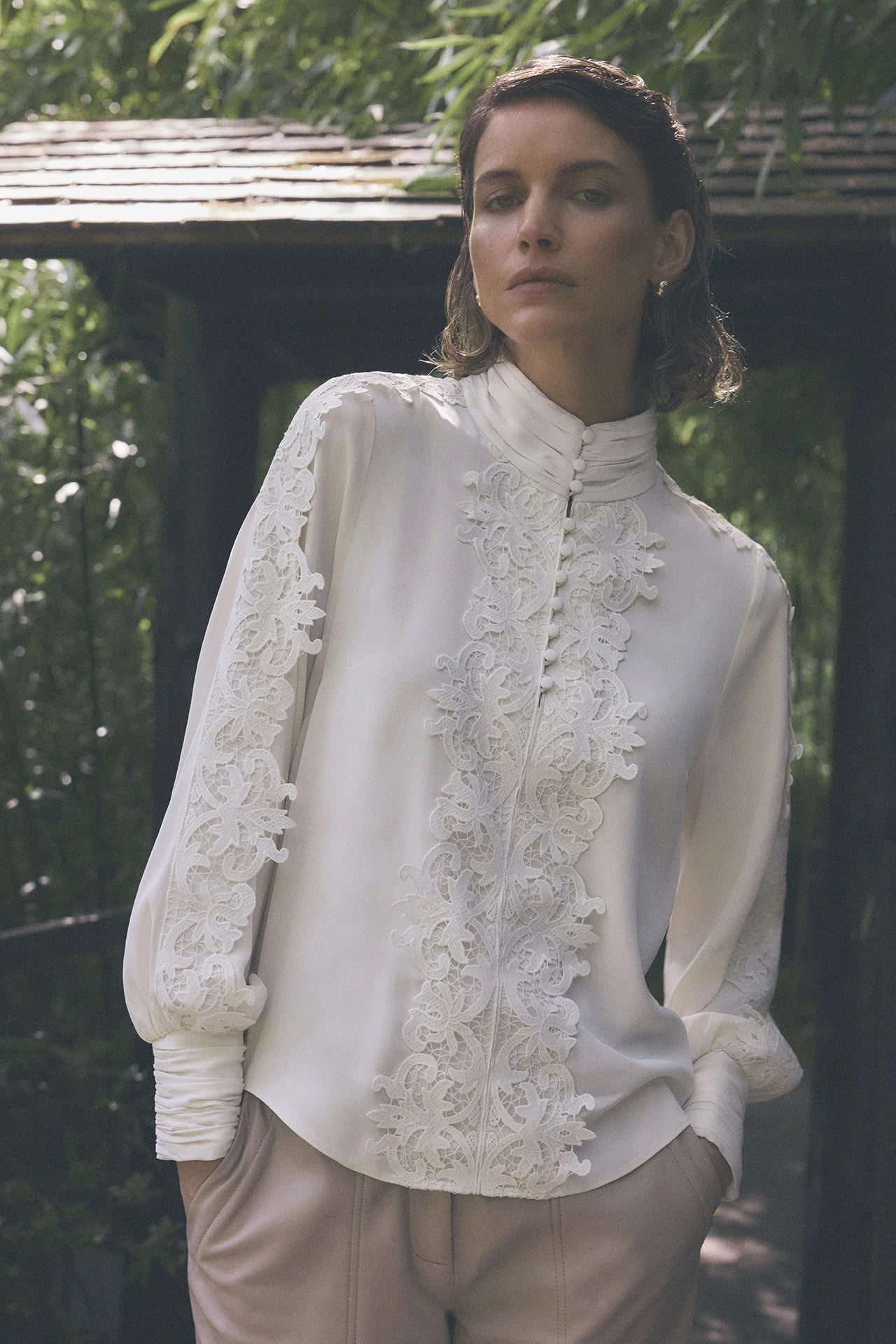 Gustav Cana off-white lace embellished blouse worn by model, showing delicate lace across the front and sleeves