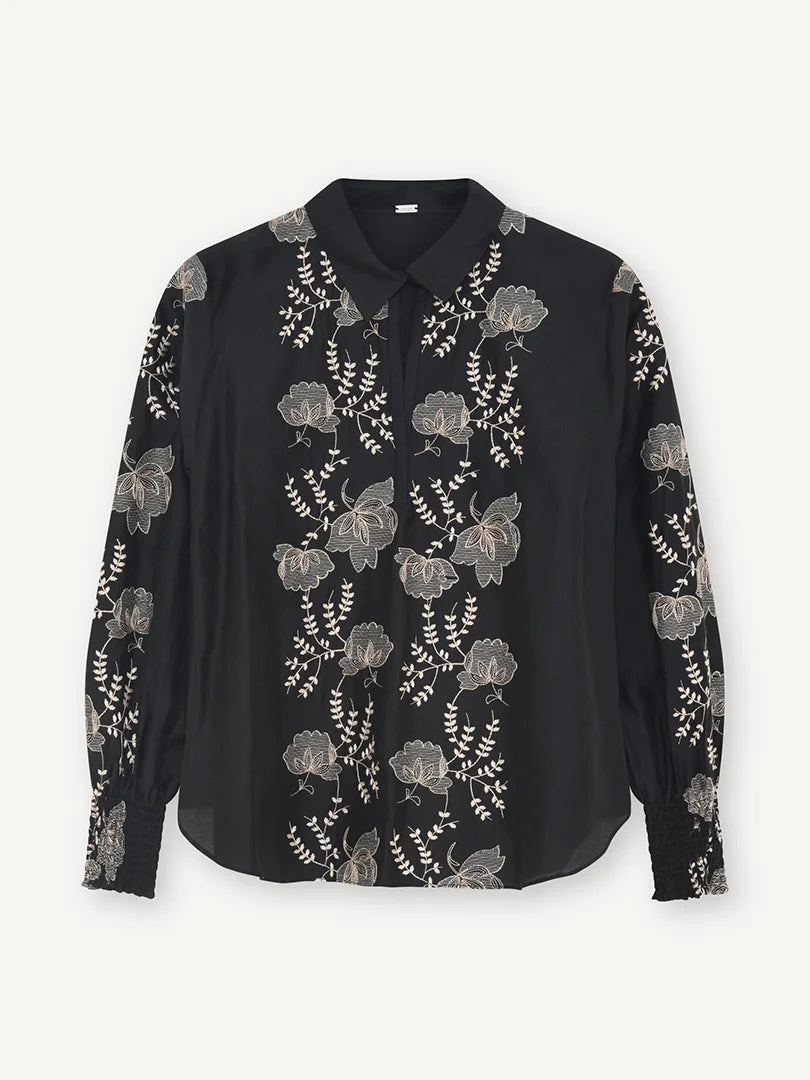 Gustav Bayanna black blouse with intricate ivory floral embroidery, classic collar and long sleeves – front view.