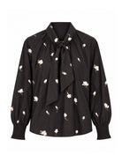 Gustav Erene dark brown floral blouse with ivory flower motifs, statement tie-neck bow and long sleeves with smocked cuffs – front view.