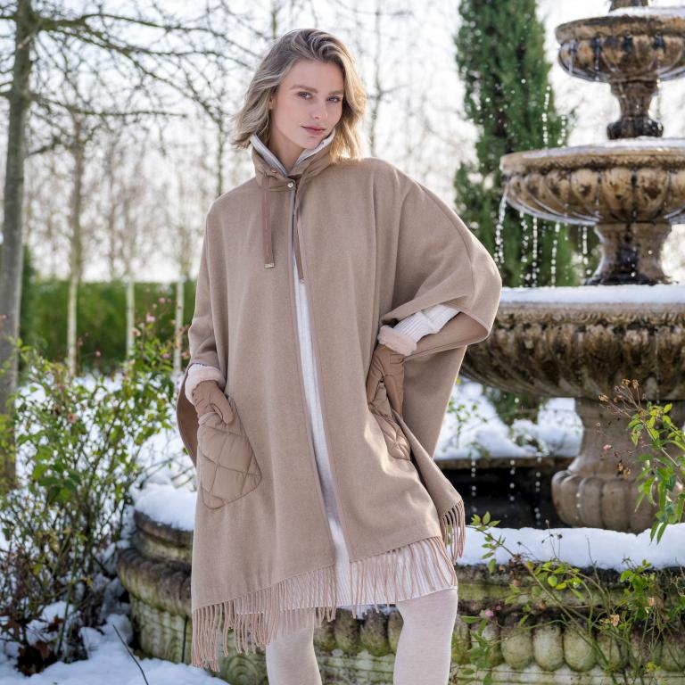     HV Society Siza camel fringed cape styled over winter layers.