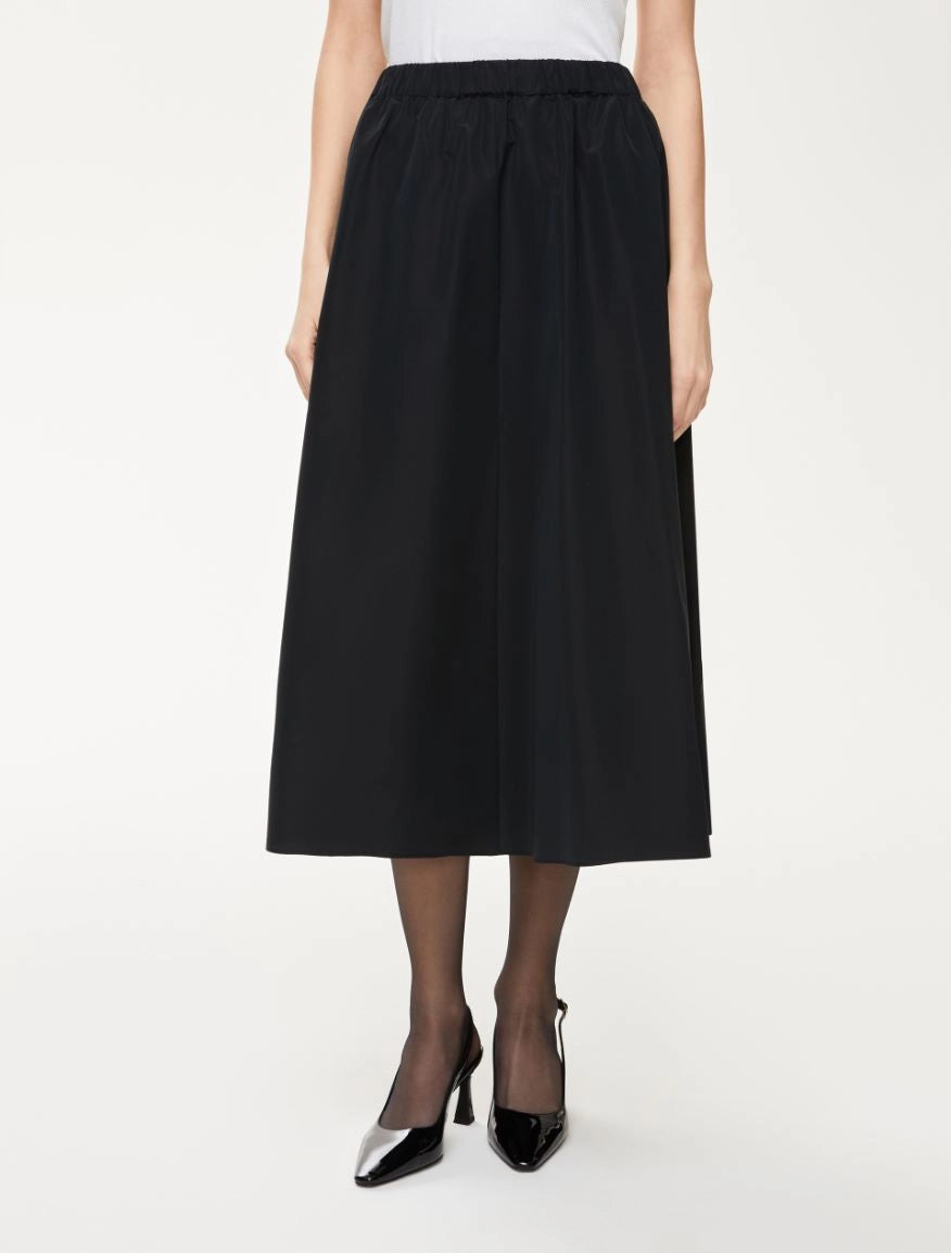 Front view of black Cavallo skirt styled with heels and sheer tights