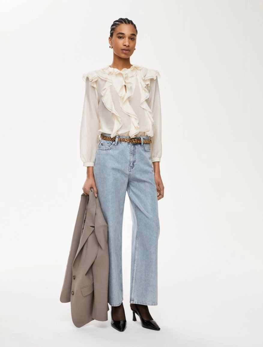 Model wearing iblues cream silk blend frill blouse with blue jeans
