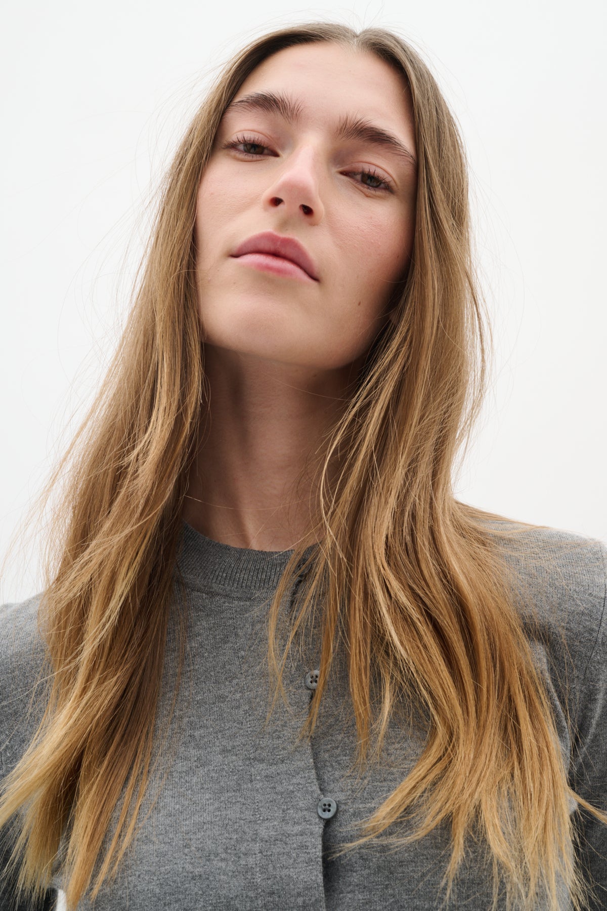 Model close-up wearing cardigan unbuttoned over matching top