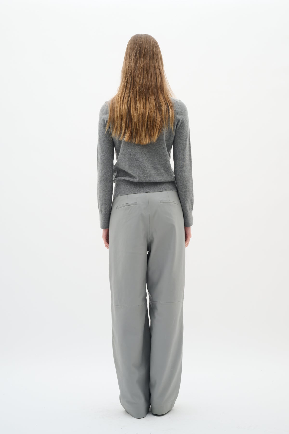 	Back view of model wearing grey crew neck cardigan and grey wide-leg trousers