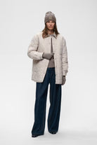 InWear Kaxy Cinder Melange beanie styled with cream quilted jacket – full model view