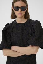 Model in sunglasses wearing InWear Brill dress with arms crossed and puff detail visible