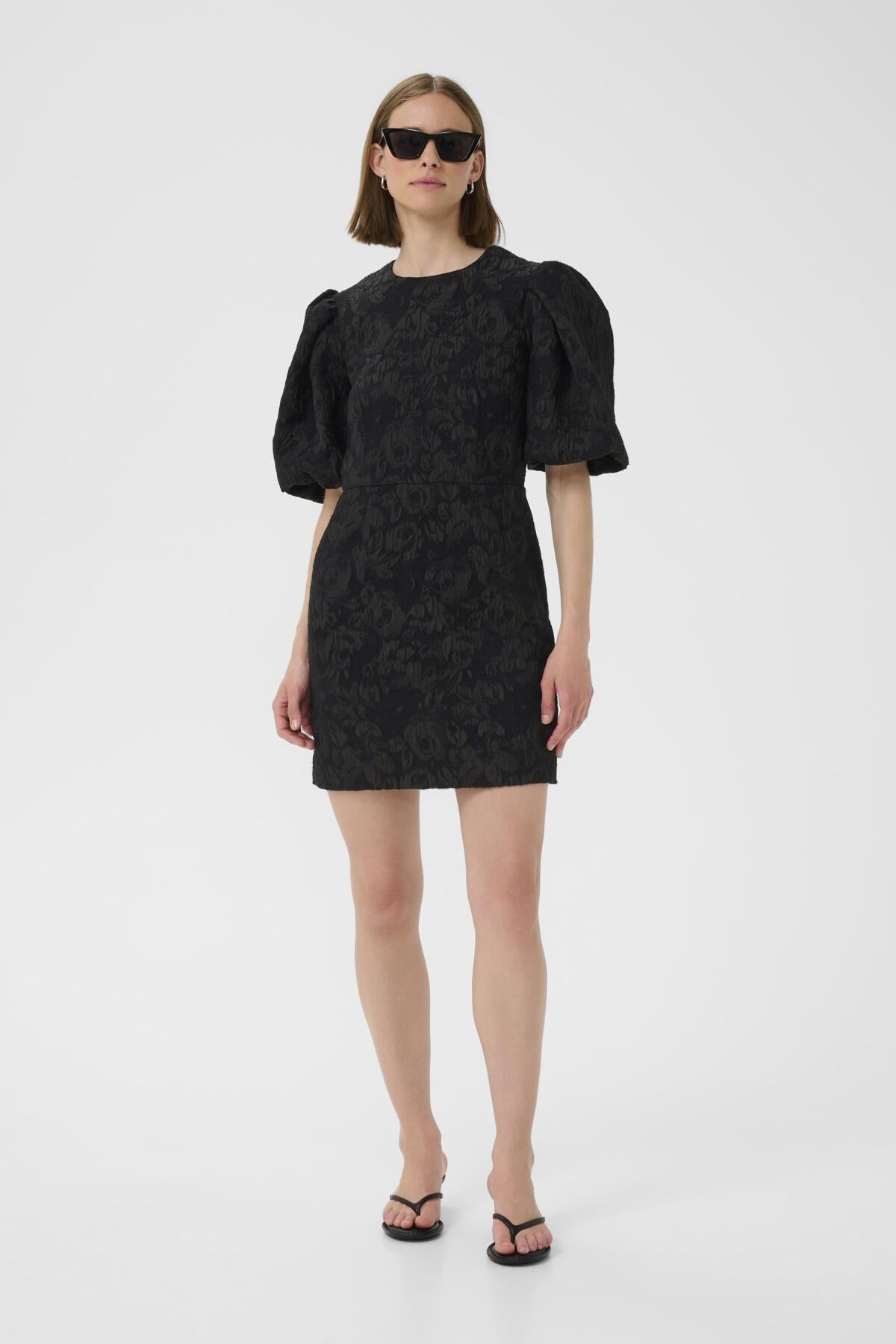 Full body view of model in InWear Brill black brocade mini dress with puff sleeves