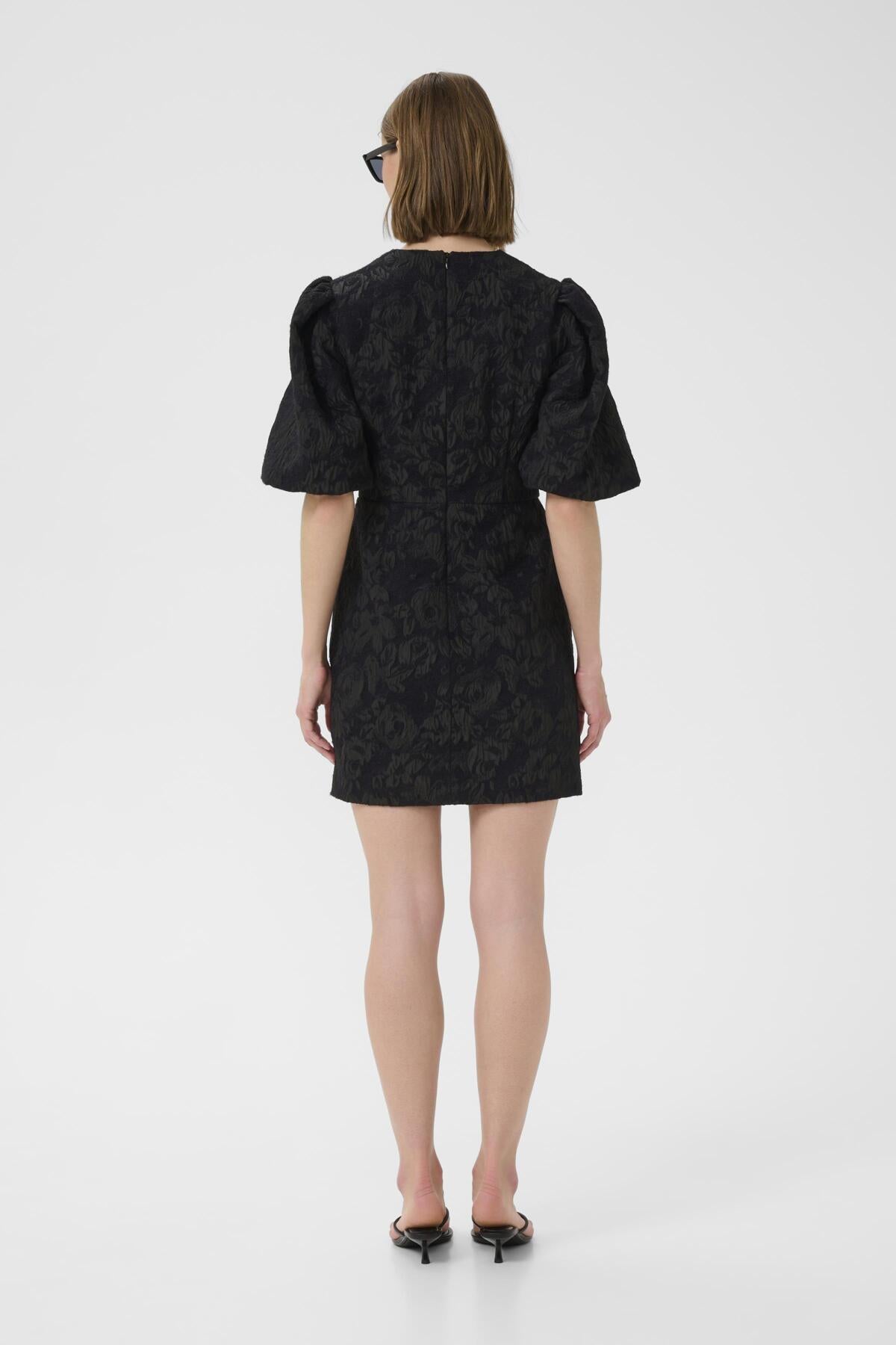 Back view of model wearing InWear Brill brocade black mini dress with structured fit