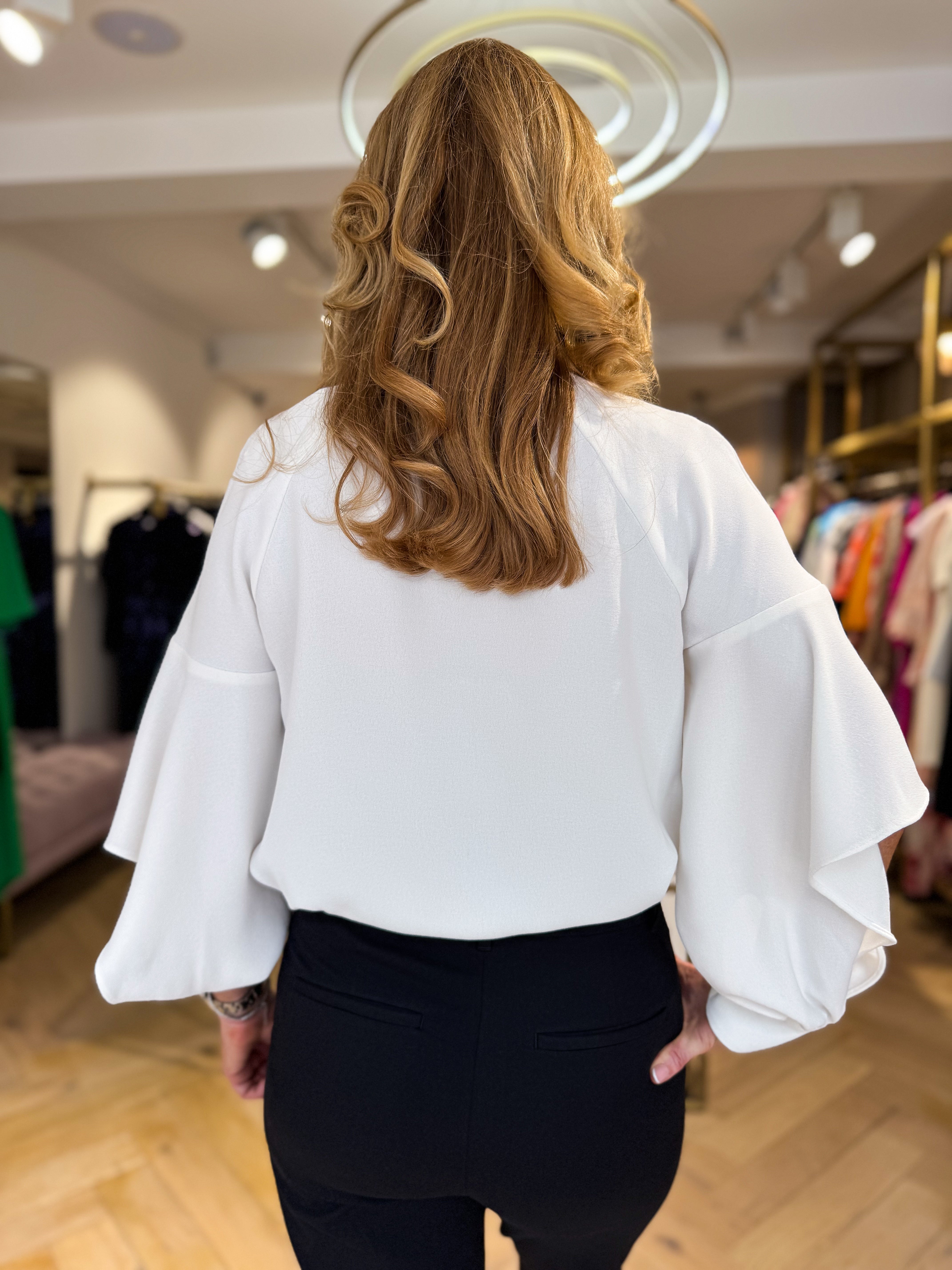 Back view of Kameya blouse showcasing split sleeve detail and feminine silhouette