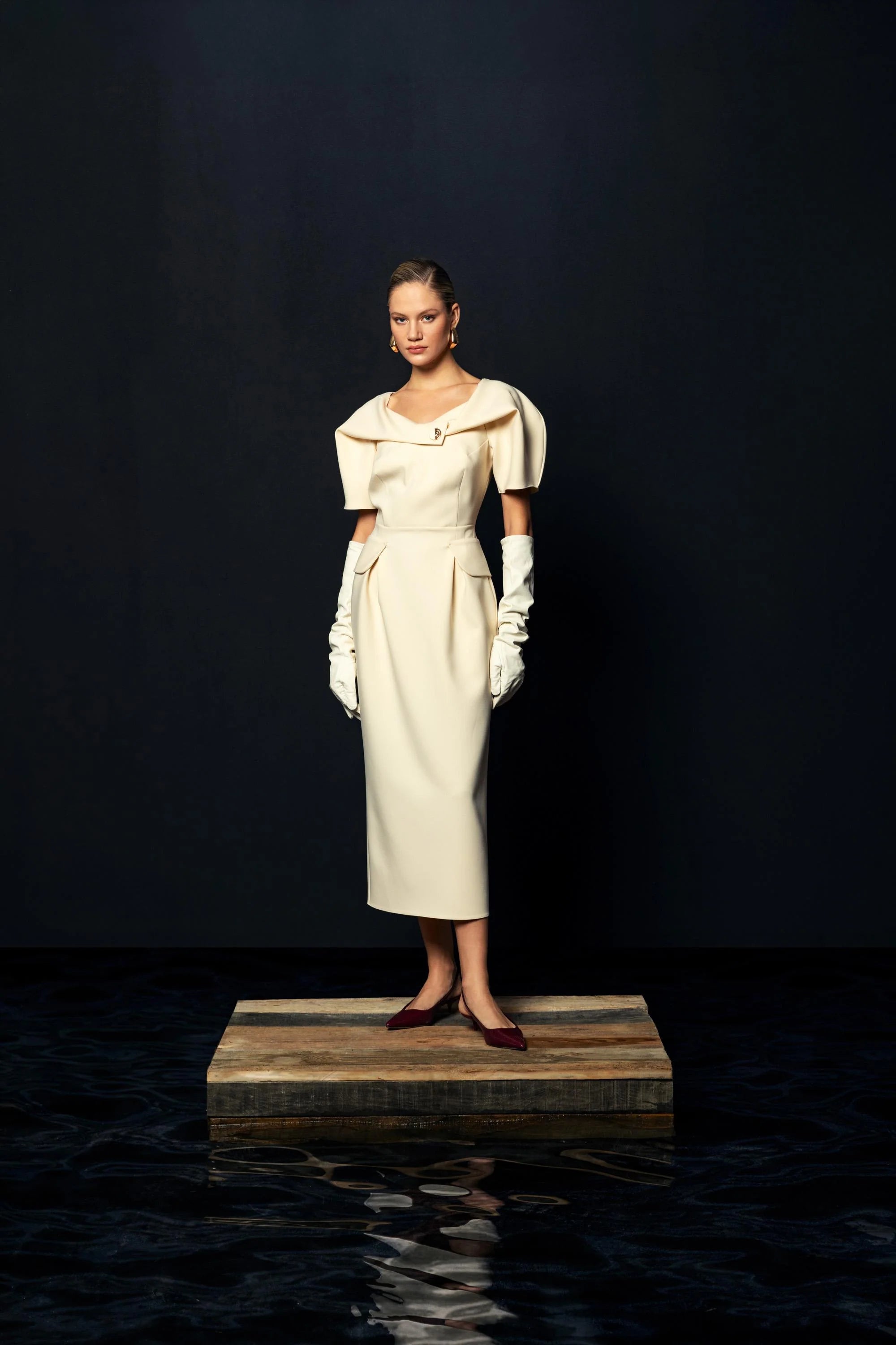 Front studio shot of Kameya Draped Shoulder Midi Dress styled with gloves