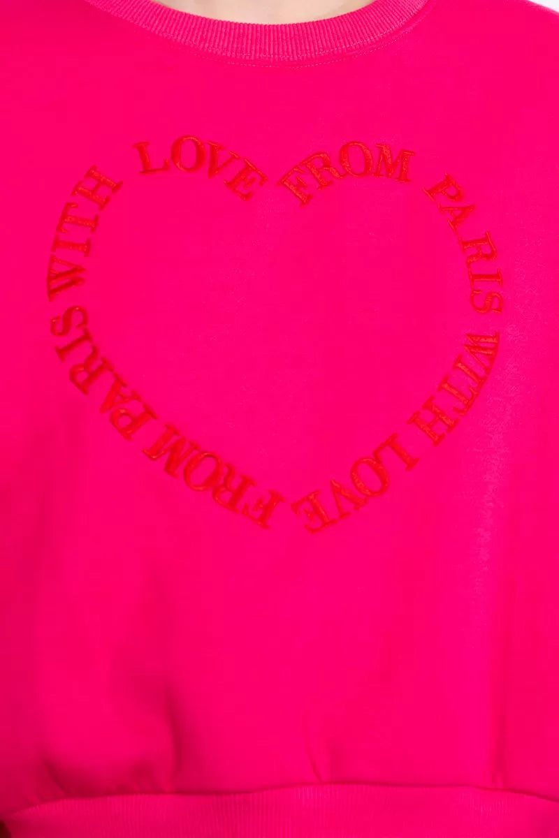 Close-up of Lili Sidinio “With Love from Paris” motif in circular heart design