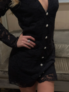 Model wearing Love Lolina black lace dress with deep V and button detail From back 