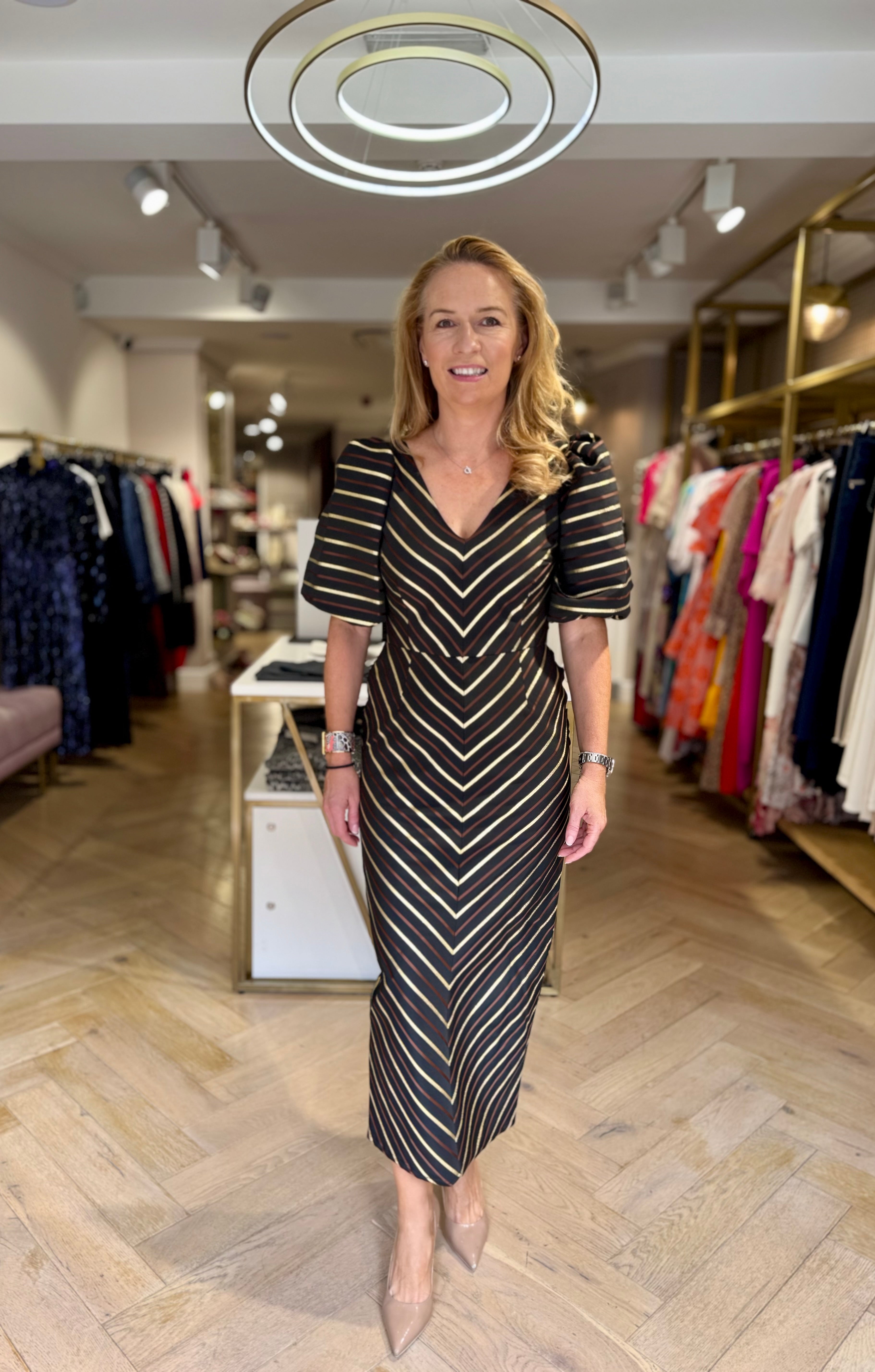 Joanne Mallon wearing Matilde Cano chevron midi dress with puff sleeves, walking in Ribbon Rouge boutique