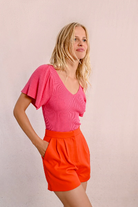 Molly Bracken pink ribbed knit top with ruffled sleeves and V-neckline