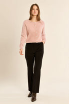 Molly Bracken pink fluffy knit cardigan worn with black trousers – full model view