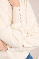 Close-up of sleeve bow detail on Molly Bracken knitted jumper