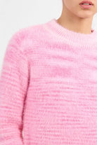 Molly Bracken soft pink fluffy knit jumper with dark trousers 