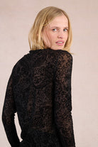 Side profile of Molly Bracken sheer black paisley mesh top with long sleeves.