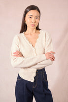 Close-up of Molly Bracken cream cardigan neckline with lace trim and pearl buttons.