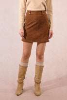 Molly Bracken camel faux suede mini skirt styled for autumn with high boots and beige turtleneck.