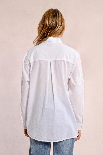 Back view of oversized white embroidered shirt with soft pleats