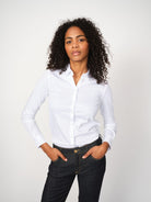 Woman wearing Mos Mosh Tina Jersey Shirt in white, styled with dark denim jeans.