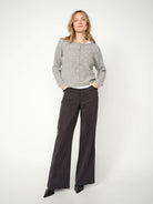Model wearing Mos Mosh Dara Treasure Wide Leg Trousers in dark grey with grey cardigan and pointed heels.