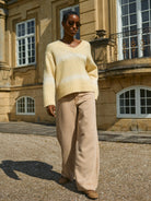 Model wearing Mos Mosh beige wide-leg trousers and cream knit