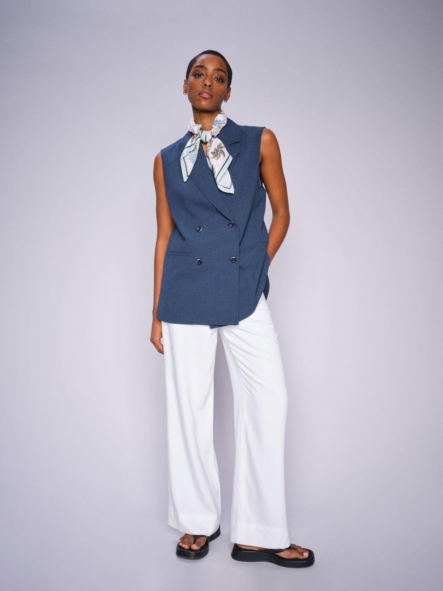 Model in navy sleeveless top and Mos Mosh white wide-leg trousers