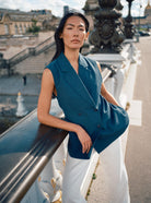 Mos Mosh white trousers styled with teal sleeveless top on city bridge