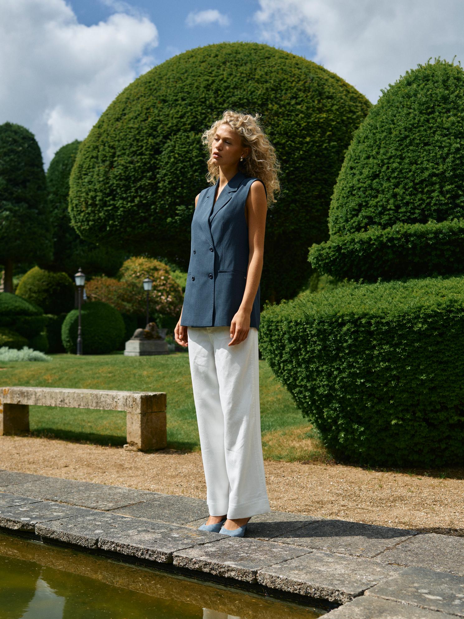 Model wearing Mos Mosh white wide-leg trousers