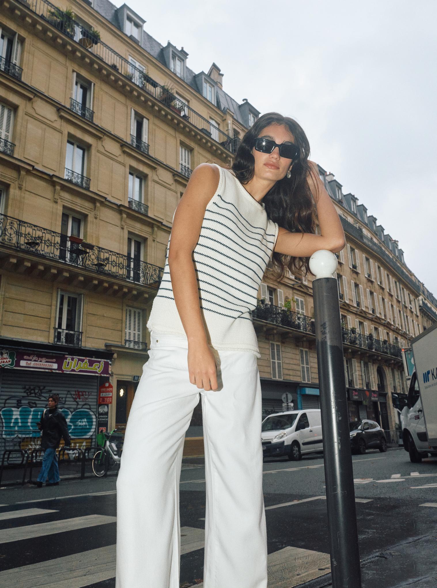 Model wearing Mos Mosh wide-leg lyocell trousers in white on city street