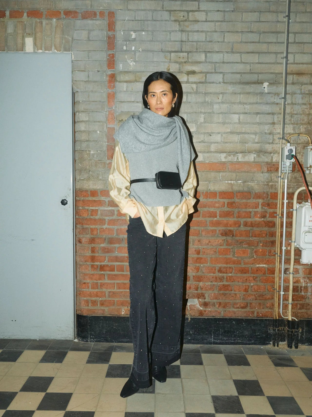 Model styling Mos Mosh grey sleeveless vest over yellow shirt