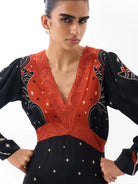 NOIB Aura black and orange-red maxi dress showing decorative V-neckline and hand-beaded detail – close-up.