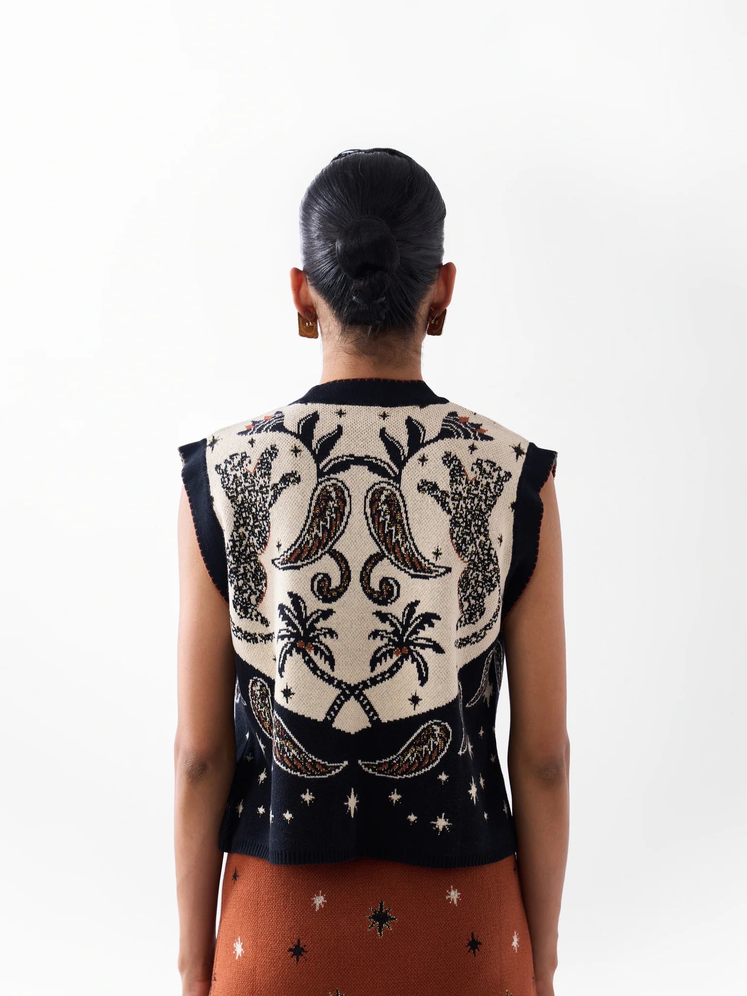 NOIB Lola Nocturnal Jungle sleeveless knitted vest showing palm trees and paisley motifs – back model view.