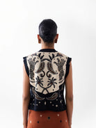 NOIB Lola Nocturnal Jungle sleeveless knitted vest showing palm trees and paisley motifs – back model view.