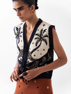 NOIB Lola knitted waistcoat with V-neck, tie-front fastening and tropical jacquard pattern – close-up.