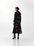 NOIB Willow black printed maxi dress showing decorative motifs across the back – rear model view