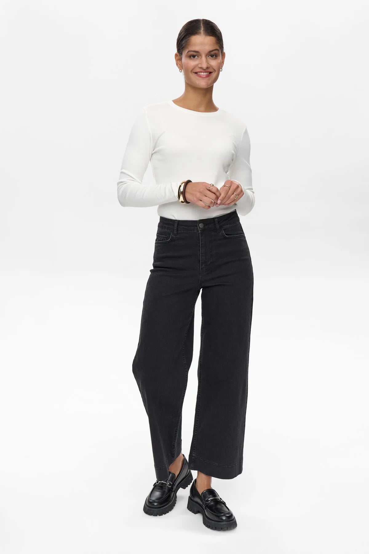 Model wearing Numph Nuparis high waisted cropped black jeans with flared leg, front view.