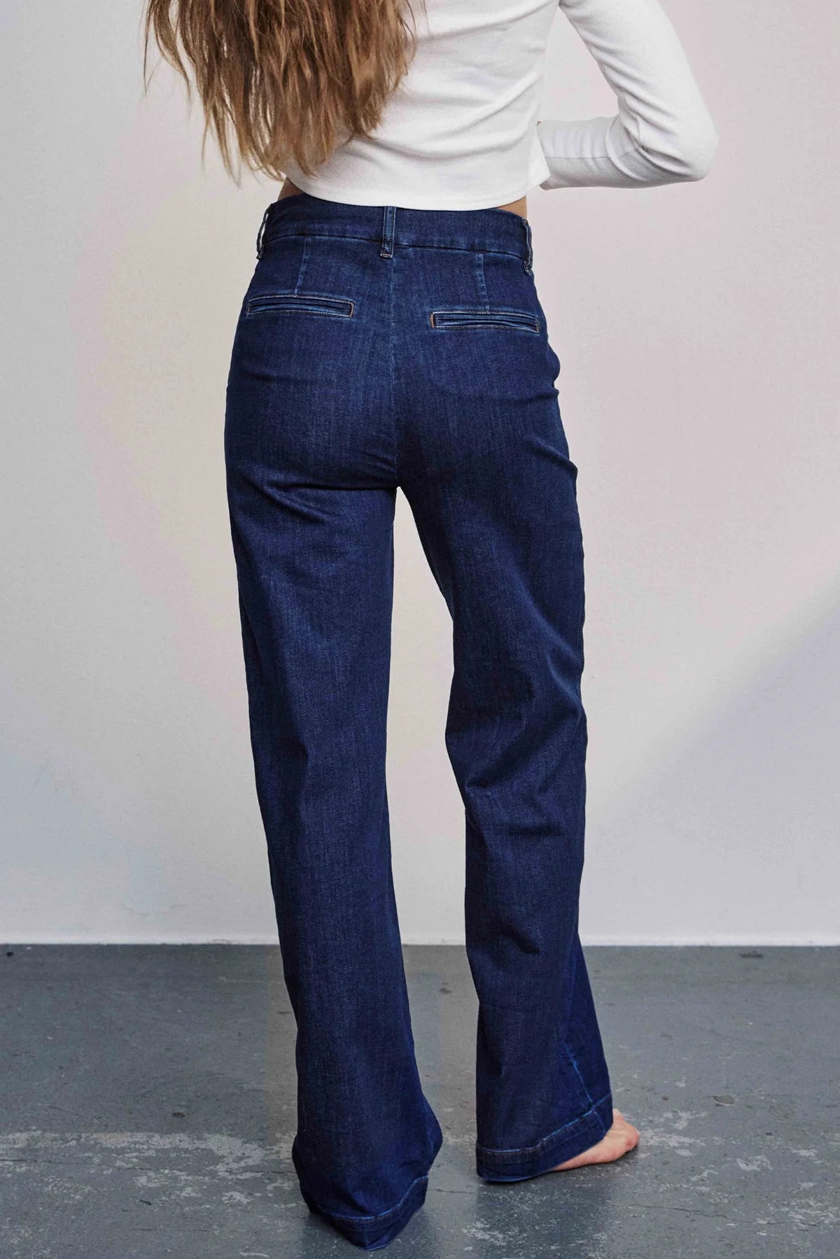 Close up Back view of Nümph Nuamber flared denim jeans in dark blue, high-rise fit with welt pocket detail.