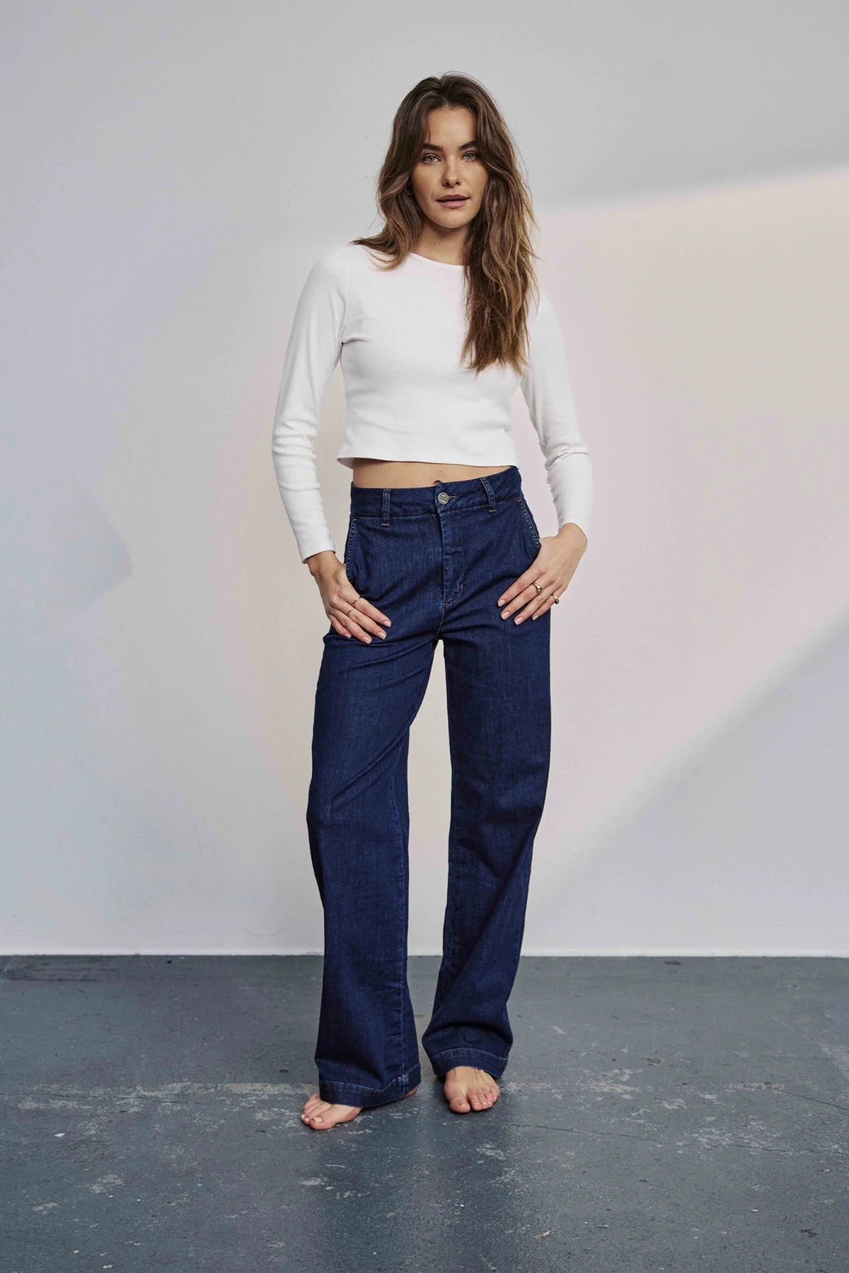 Model wearing Nümph Nuamber flared denim jeans in dark blue wash, high-rise wide-leg fit, front view.