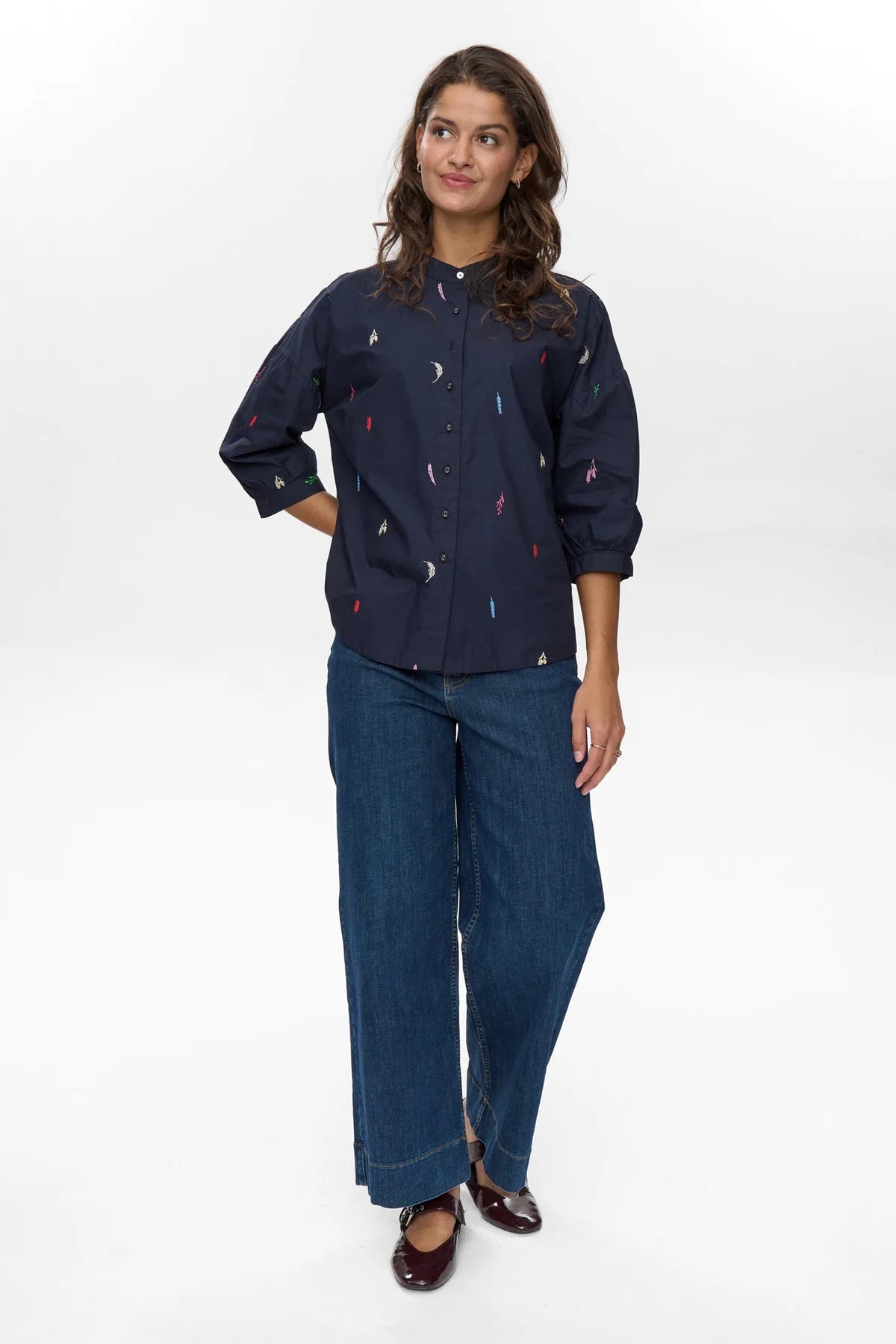 Model wearing Numph Nukiva navy embroidered shirt with wide-leg jeans