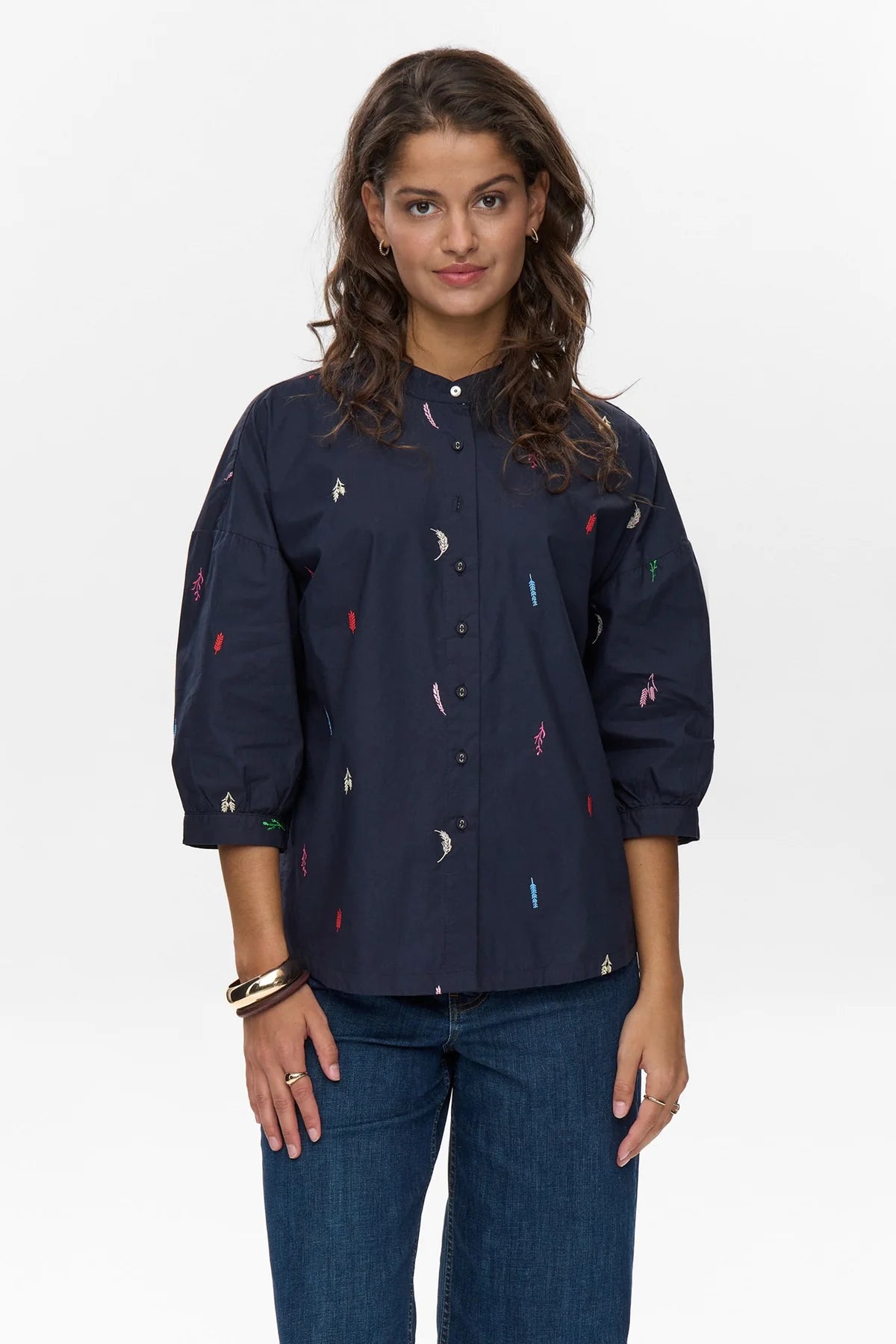 Front view of Numph Nukiva embroidered navy shirt styled with denim
